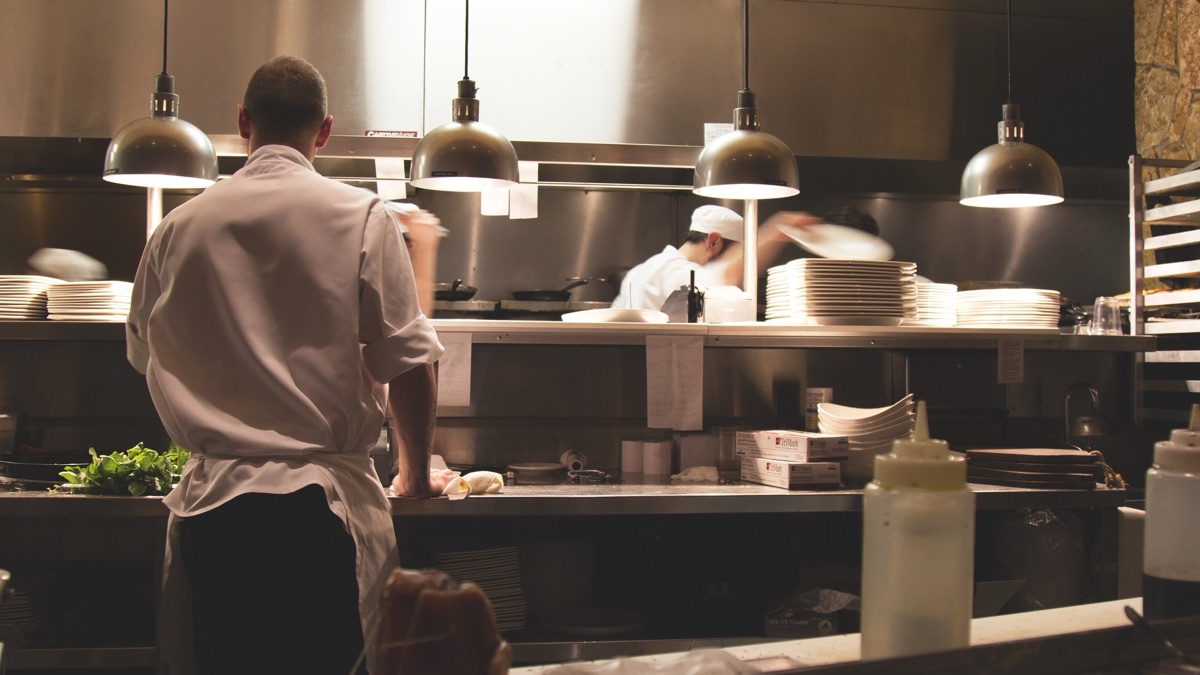 Cooks finishing trays of dum biryani in the stainless-steel kitchen of Mubarak Restaurant in Medchal, Hyderabad, before they leave for a catered event