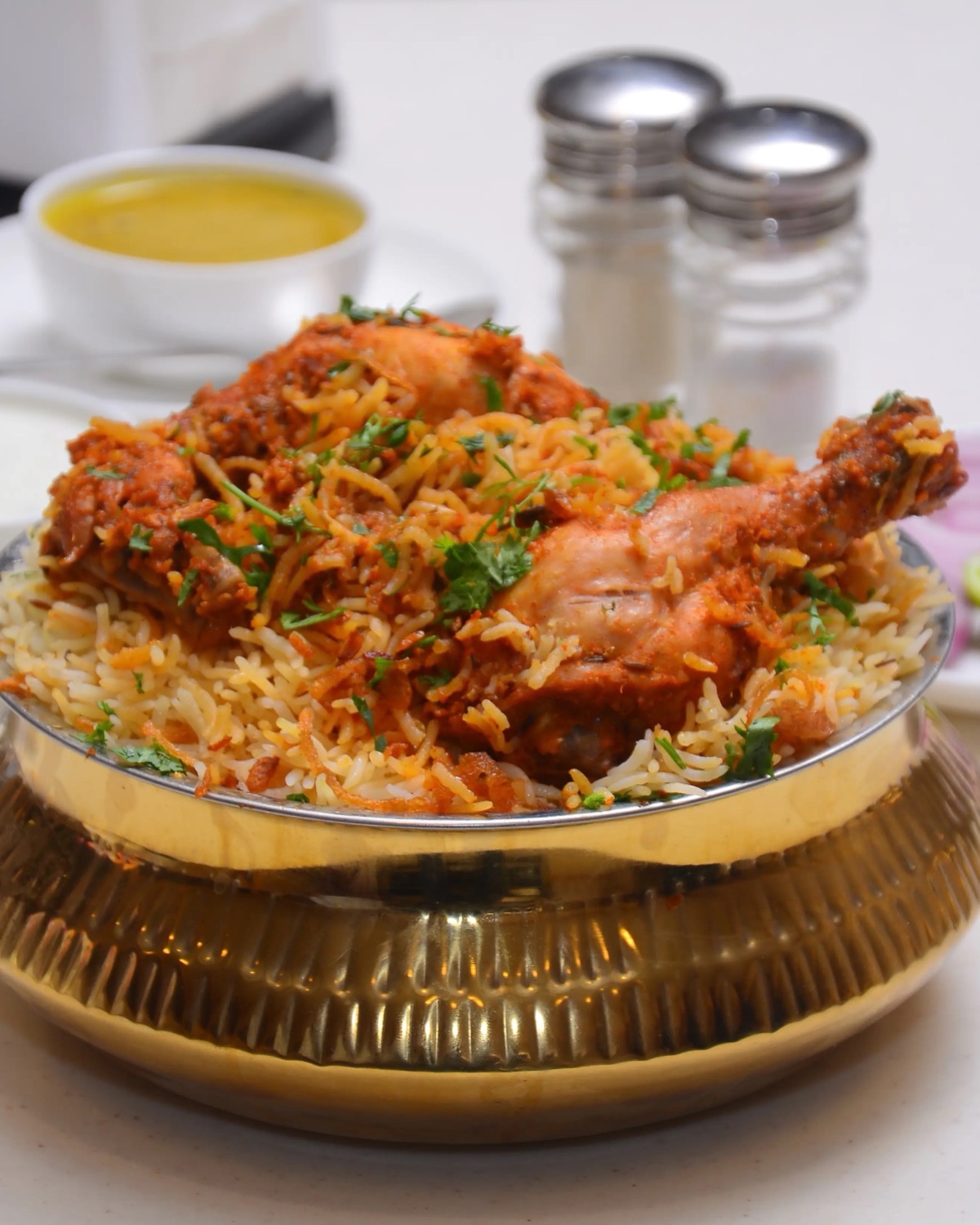 Hyderabadi buffet of biryani, kebabs and curries in brass dishes with service staff behind
