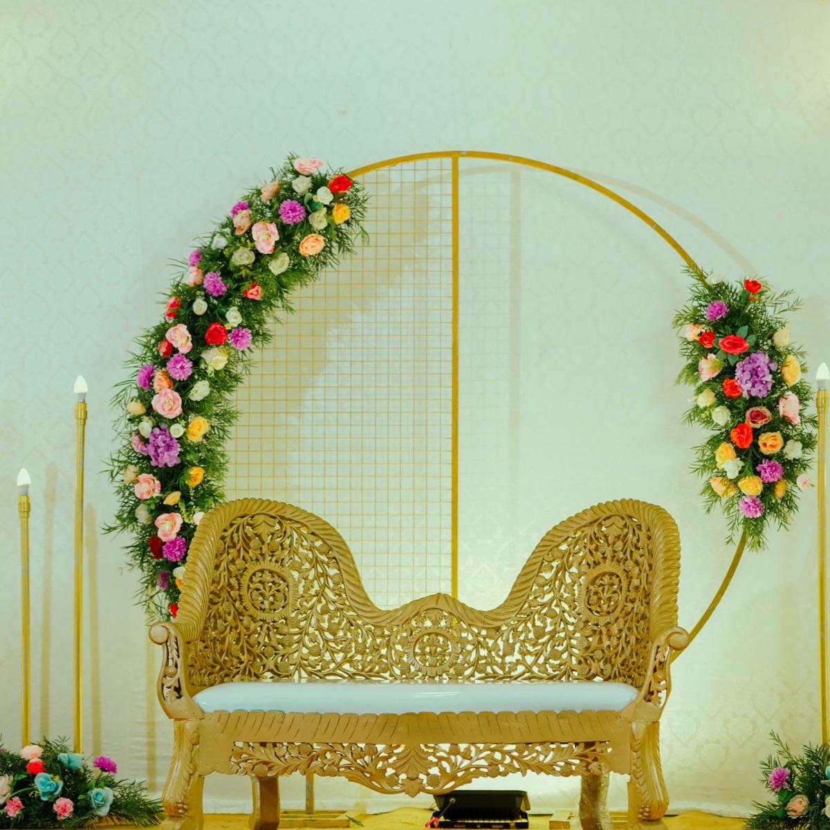 Engagement stage framed by a circular floral arch and pink drapes