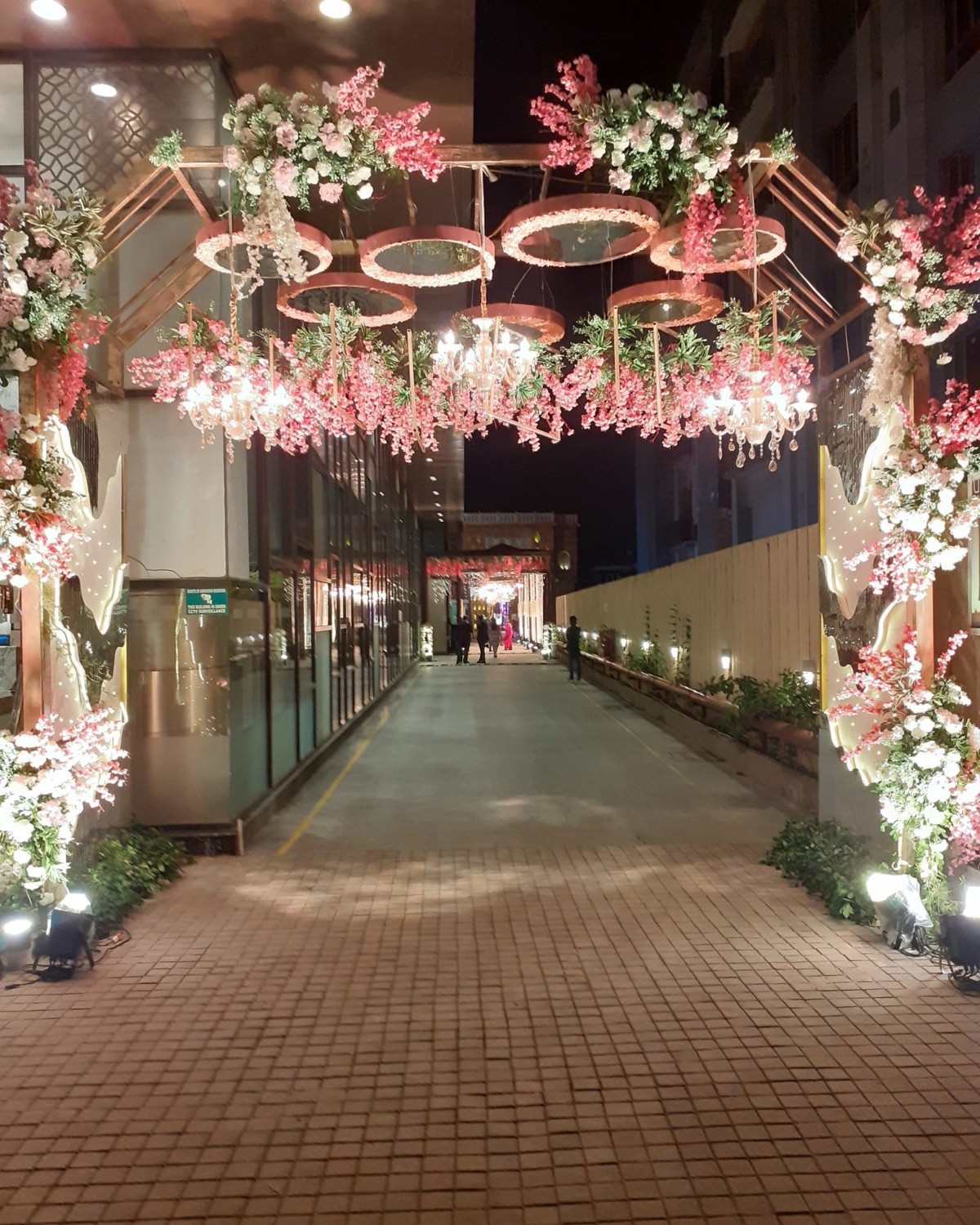 Entrance arch of white roses and jasmine strands at a wedding venue