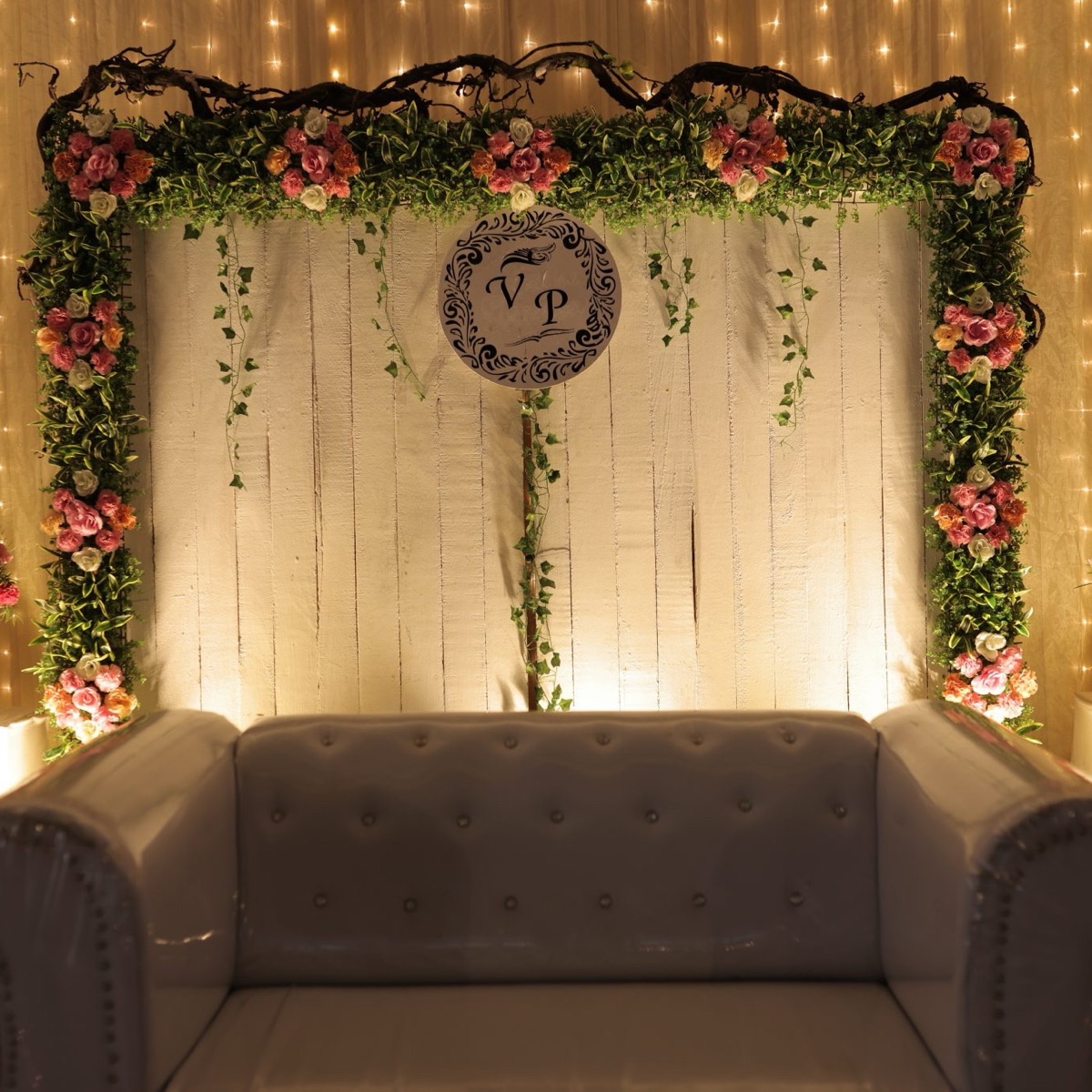 Warm white LED wall spelling a couple's initials in a photo corner
