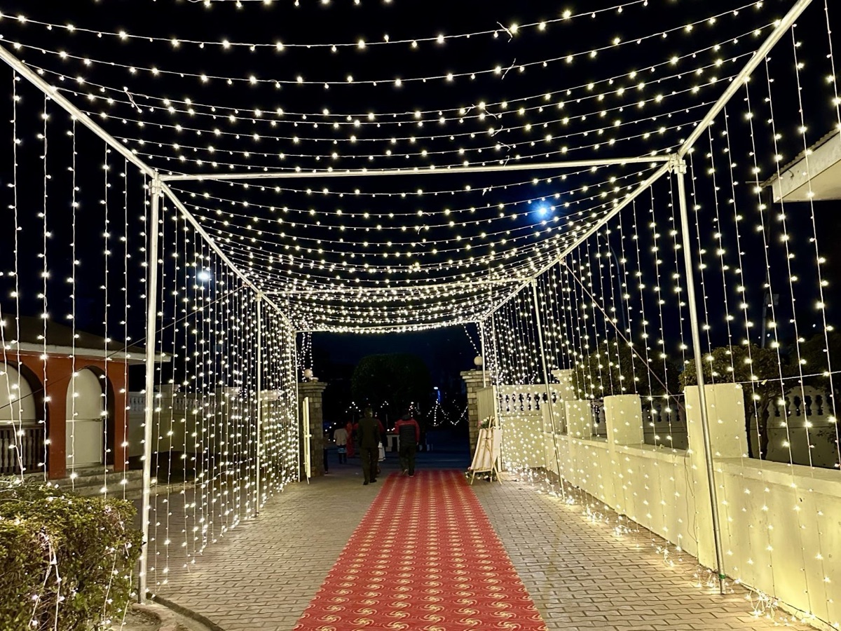LED pathway lights and a lit welcome arch leading guests into a wedding hall