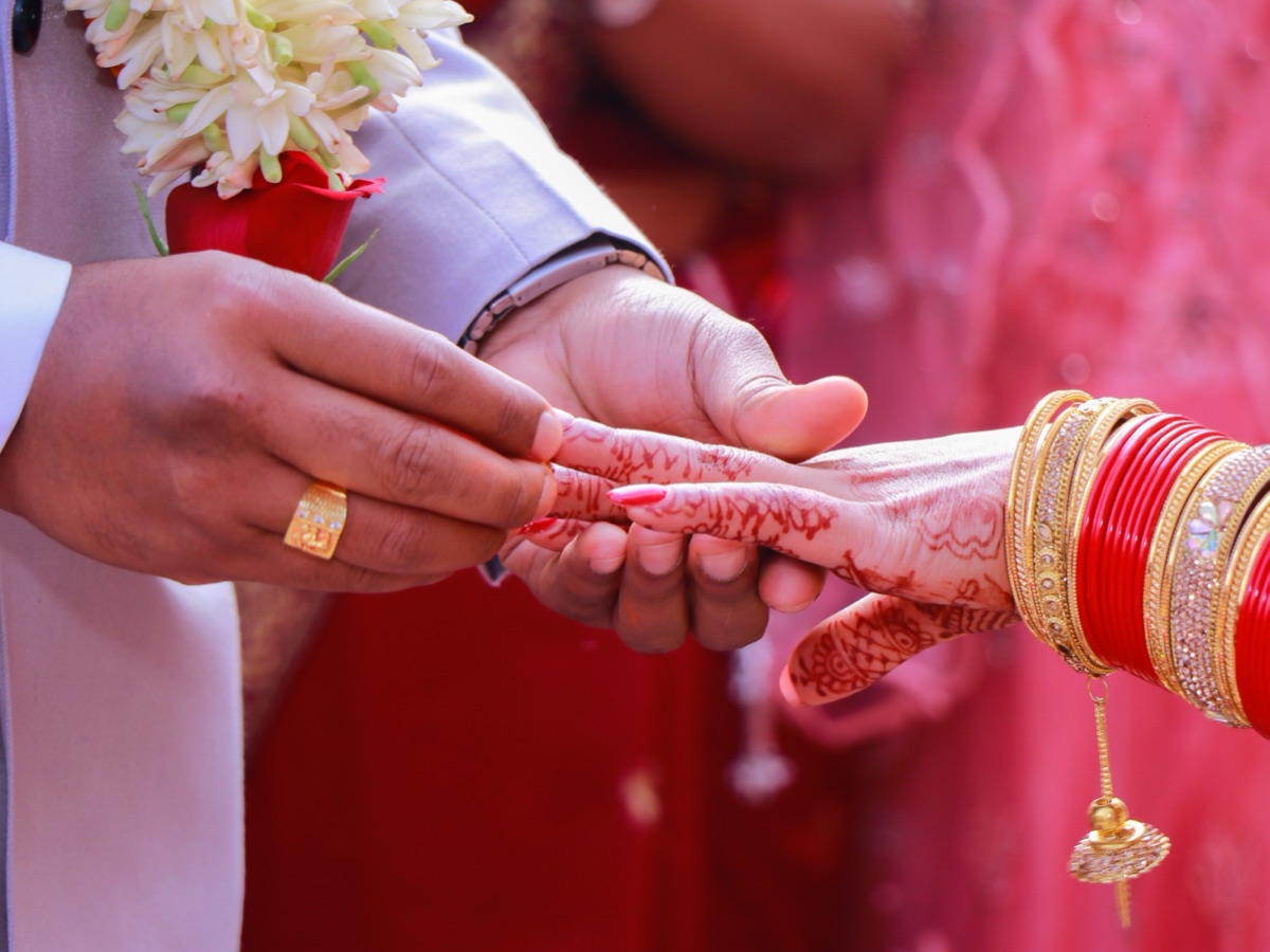 Engagement ring ceremony on a floral-arch stage with family gathered around