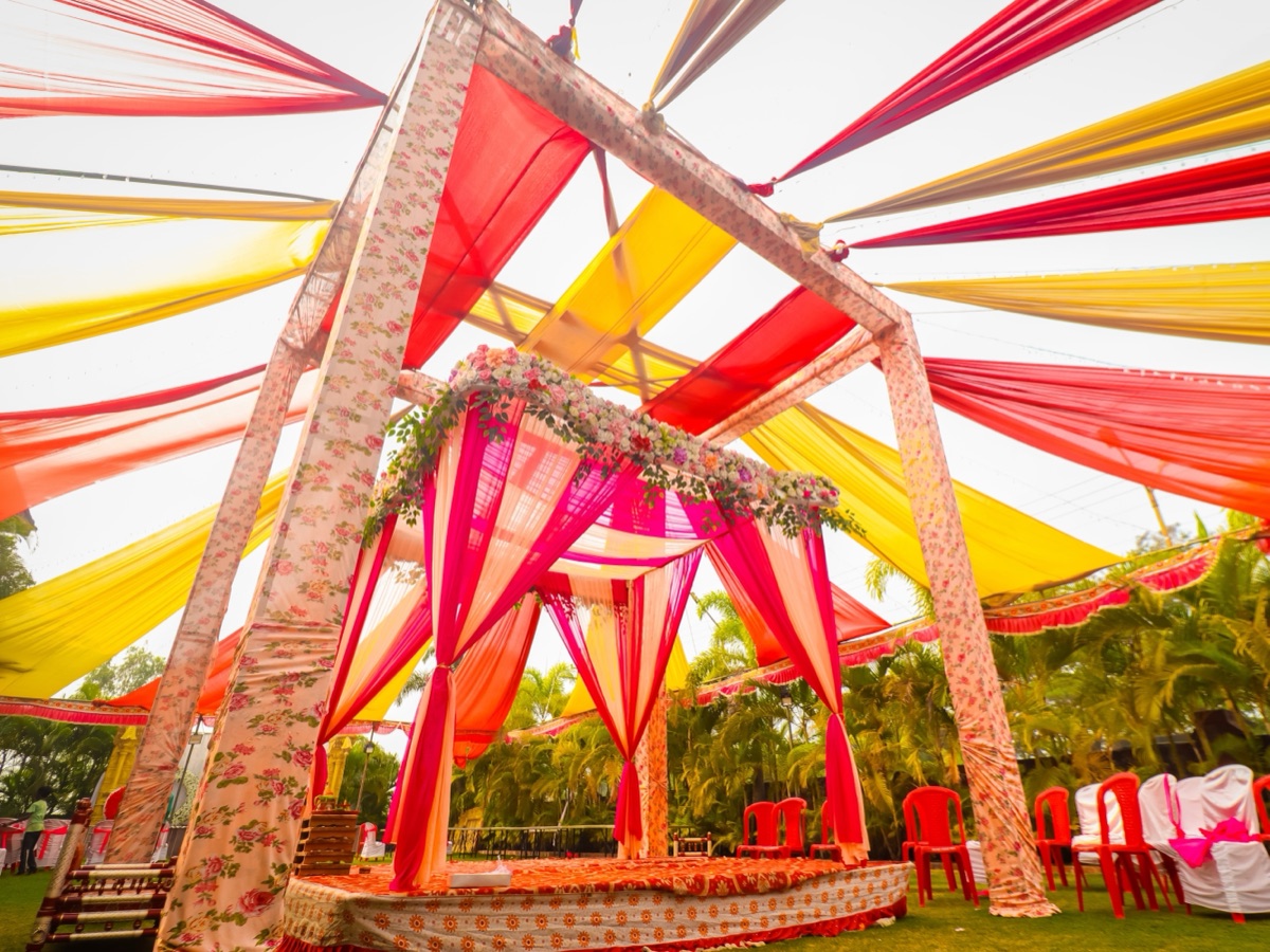 Muhurtham wedding mandap with marigold strands and seated guests before the ceremony