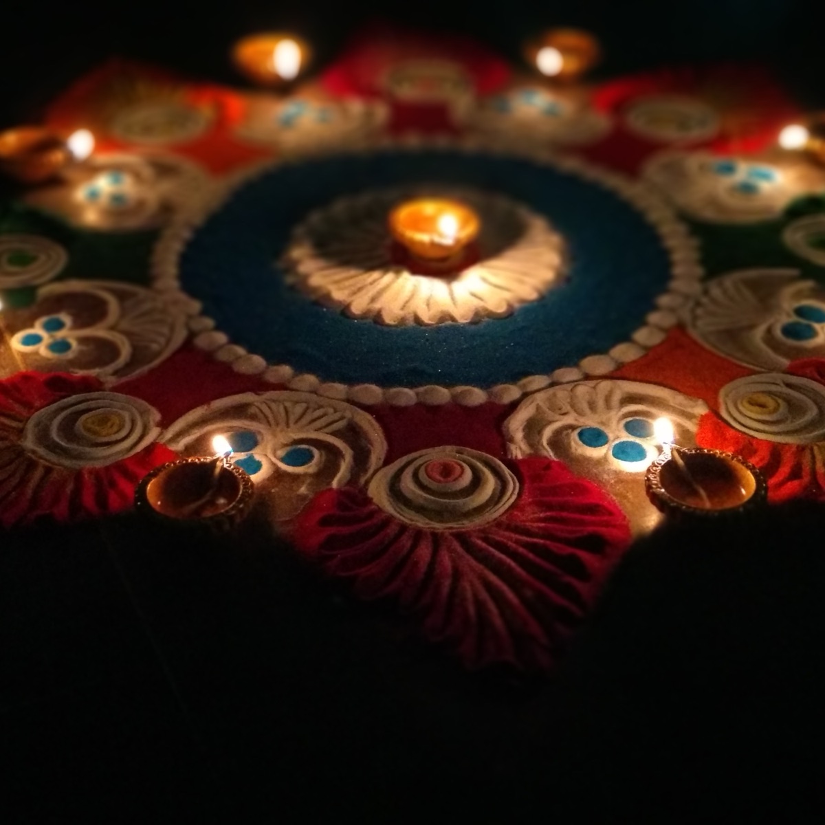 Office Diwali celebration with lamps, rangoli and staff gathered around a buffet