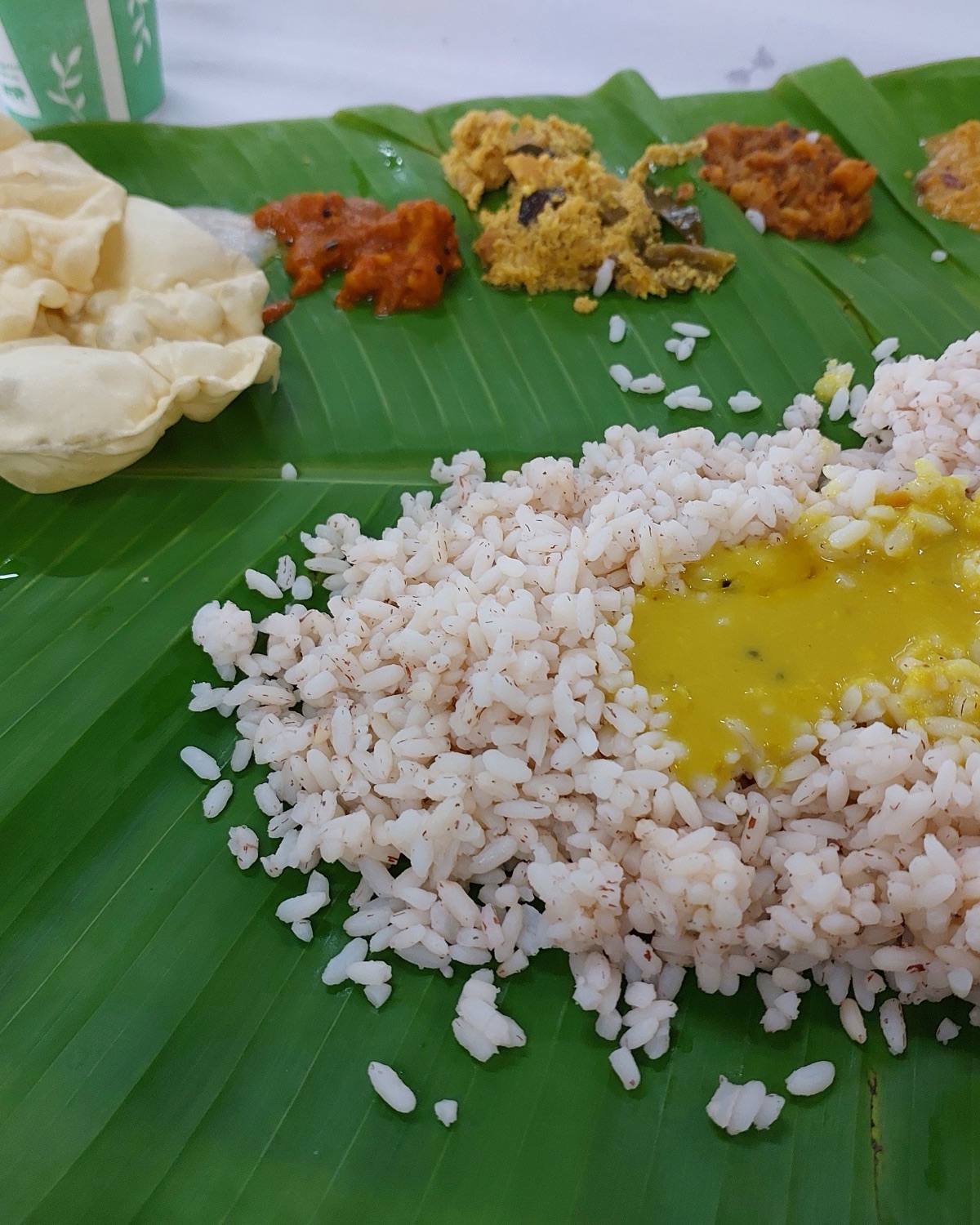 Vegetarian function lunch served on banana leaves with sambar, rice and sweets