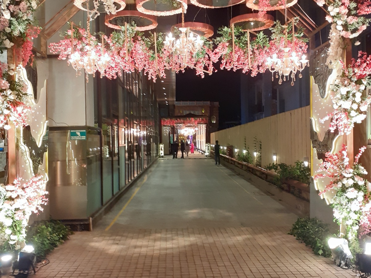 Floral welcome gate and guest reception desk at a wedding hall entrance