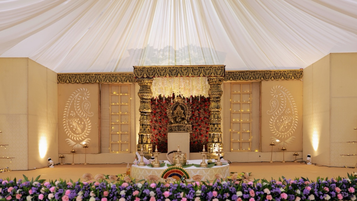 Wedding planners in Hyderabad: a decorated wedding hall ready for guests, with stage, floral arch and round tables