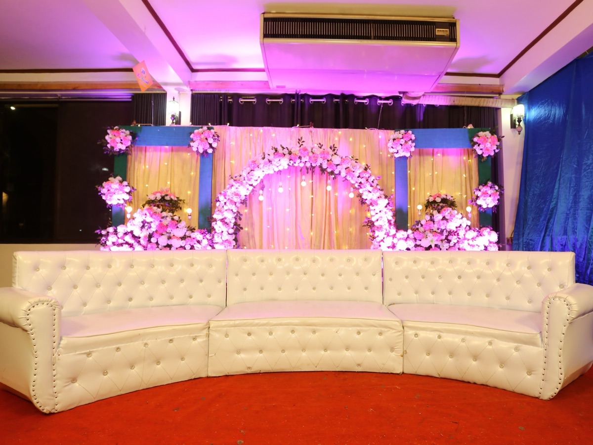 Sangeet stage lit in magenta with guests dancing on the floor